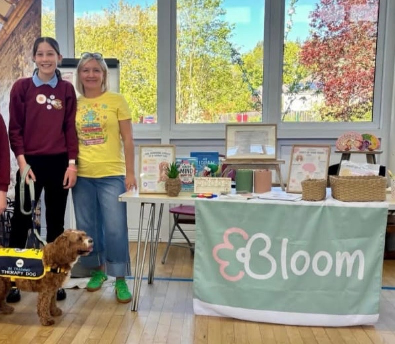 Bloom wellbeing stand at a school event with Ivy the therapy dog